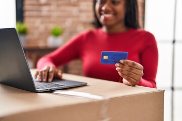 Wall Mural - African american woman smiling confident using laptop and credit card at new home