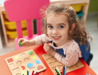 Canvas Print - Adorable blonde girl playing with maths puzzle game sitting on table at kindergarten