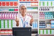 Middle age woman with tattoos working at pharmacy drugstore showing middle finger doing fuck you bad expression, provocation and rude attitude. screaming excited