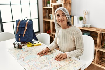 Canvas Print - Middle age grey-haired woman smiling confident preparing travel at home