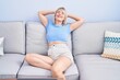 © Krakenimages.com - Young blonde woman relaxed with hands on head sitting on sofa at home