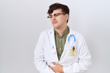 Poster - Young non binary man wearing doctor uniform and stethoscope with hand on stomach because nausea, painful disease feeling unwell. ache concept.