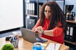 © Krakenimages.com - African american woman business worker using laptop looking clock at office