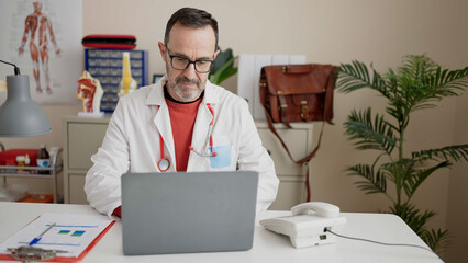 Sticker - Middle age man doctor using laptop working at clinic