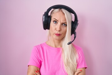 Sticker - Caucasian woman listening to music using headphones skeptic and nervous, disapproving expression on face with crossed arms. negative person.