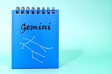 Wall Mural - Gemini zodiac sign on blue desk calendar notepad. Horoscope and astrology concept.