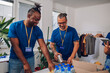 © Zamrznuti tonovi - Diverse volunteers working in a charity donation center and packing clothes and food