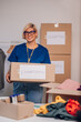 © Zamrznuti tonovi - Portrait of a woman volunteer working in a charity donation center