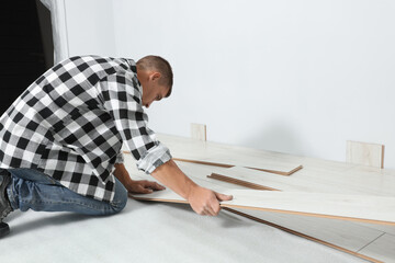 Wall Mural - Professional worker installing new laminate flooring indoors