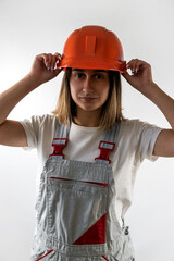 Wall Mural - Young female architect builder posing in uniform and helmet smiling.