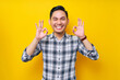 © Bangun Stock Photo - Cheerful young handsome Asian man wearing casual clothes showing okay sign isolated on yellow background. People lifestyle concept