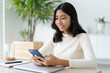 © sorrapongs - Asian woman using smartphone in morning at home