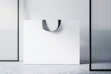 Poster - Front view on blank white paper shopping bag with place for your brand name or text on light concrete floor and light wall background, close up. 3D rendering, mockup