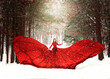 © Cavan Images - Young redhead girl in flowing red dress in forest with snowfall.