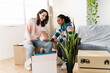 © Westend61 - Happy multiracial friends looking at frame in home