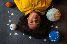 Overhead View Of Cute Girl Lying Amidst Solar System