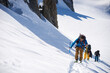 © Cavan Images - Group of 3 people ski touring up hill