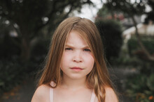 Portrait Of A Young Girl With A Serious Face Standing Outside