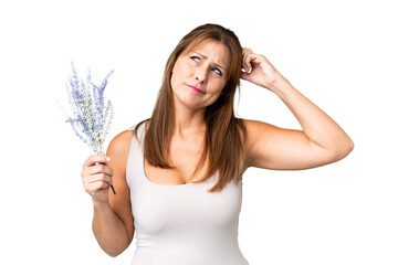 Canvas Print - Middle age caucasian woman holding lavender over isolated background having doubts and with confuse face expression