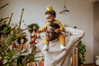 © Westend61 - Happy man with daughter touching Christmas ornaments at home