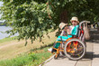 © Westend61 - Happy woman looking at daughter with disability enjoying at sunny day