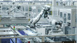 © IM Imagery - Automated Manufacturing Facility. White Industrial Robot Arm at Production Line at Modern Bright Factory. Solar Panels are being Assembled on Conveyor.