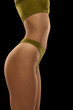 © Lustre Art Group  - Side view of female body in green inner wear isolated over dark background. Anti-cellulite care cosmetology. Concept of beauty, body care, health, plastic surgery