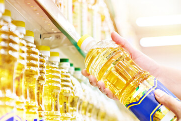 Wall Mural - Sunflower oil in hands at store