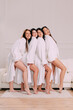© MZaitsev - Portrait of four smiling young women in bathrobes.