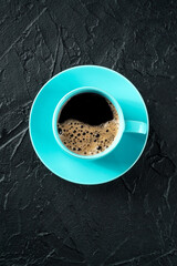 Poster - Coffee cup, shot from the top on a black slate background with copy space, espresso drink in a vibrant teal mug