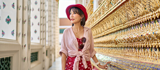 Wall Mural - thai woman enjoying looking at ornate walls of wat arun temple in bangkok thailand