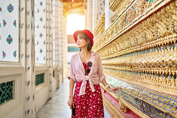 Wall Mural - thai woman enjoying looking at ornate walls of wat arun temple in bangkok thailand