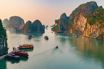 sunset over the halong bay, boats in a body of water with mountains in the background, boats in a bo