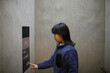 冬のエレベーターの中で家の階のボタンを押す小学生の女の子の様子