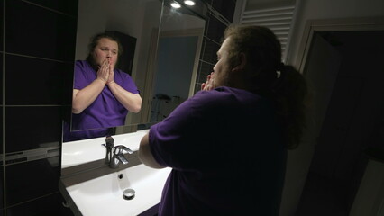 Confused sad man leaning on bathroom sink in dilemma and doubt. Person suffering from mental illness