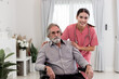© butsaya33 - Caucasian caregiver lady consulting with elderly man patient. Wheelchair disability rehabilitation and nurse at nursing home. Healthcare support and caregiver with senior man for medical help.