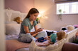 © Monkey Business - Young Diabetic Girl Sitting On Bed In Bedroom At Home Using Kit To Measure And Check Insulin Levels