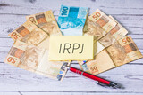 Fototapeta  - As iniciais IRPJ de Imposto sobre a Renda das Pessoas Jurídicas em Português do Brasil escrita em um pedaço de papel. Economia Brasileira.