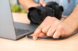 © cunaplus - Close-up of a man's hand plugging a usb cable into a laptop from a camera at home