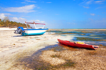 Old fisher boats on the beach during low tide on ocean.