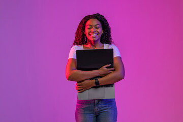 Poster - Happy Black Woman Embracing Laptop Computer With Blank Screen In Neon Light