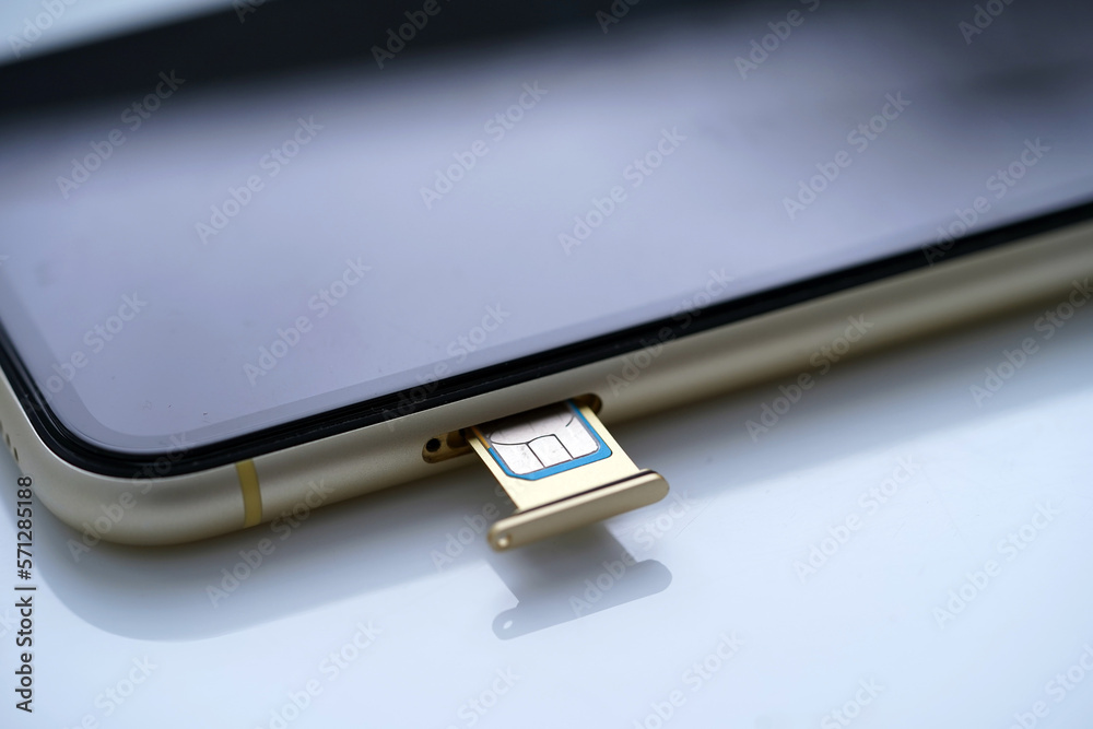 inserting a sim card into back of mobile phone, Sim card in tray being inserted into phone