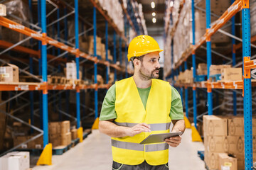 Wall Mural - A warehouseman is tracking orders online on tablet.