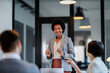 © Dusan Petkovic - A confident interracial businesswoman is standing at the boardroom with employees and having briefing about project.
