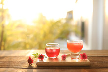 Roselle Herbal Drink And Carrot Juice And Small Red Roses On Wooden Tray Outdoor
