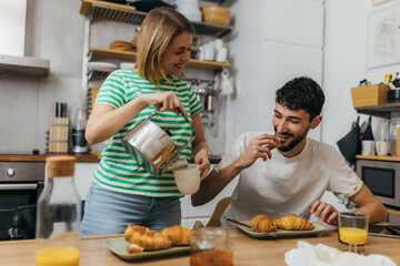 Canvas Print - A woman is pouring coffee for her boyfriend in the morning