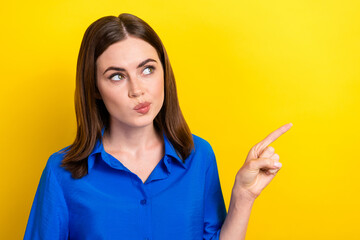 Poster - Photo of cute minded lady wear trendy blue clothes arm demonstrate empty space look interesting offer isolated on yellow color background