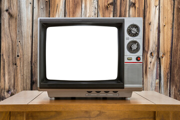 Old television on table with wood wall and empty cut out screen.