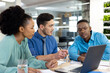 © WavebreakMediaMicro - Diverse business people using laptop and discussing in modern office