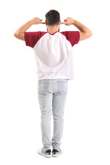 Poster - Young man suffering from loud noise on white background, back view